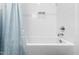 Bright white bathroom with blue curtain and alcove bathtub at 615 Daniels St # 318, Raleigh, NC 27605