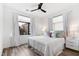 Well-lit bedroom with large window, ceiling fan, wood floors, and stylish bedding at 615 Daniels St # 318, Raleigh, NC 27605