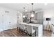 Modern kitchen with stainless steel appliances, gray cabinets, quartz countertops, and an island with barstool seating at 615 Daniels St # 318, Raleigh, NC 27605