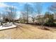 Serene backyard featuring mature trees, a brick patio with table, and lush landscaping, creating a private retreat at 627 Aylestone Dr, Cary, NC 27519