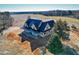New construction home with a dark metal roof and wrap around porch on a large lot at 6509 Zebulon Rd, Wake Forest, NC 27587