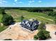 Aerial view of modern farmhouse in rural wooded location near fields and a lake at 6509 Zebulon Rd, Wake Forest, NC 27587