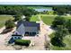 Aerial view of modern farmhouse and wooded lake and fields at 6509 Zebulon Rd, Wake Forest, NC 27587