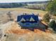 New construction home with a dark metal roof and wrap around porch on a large lot at 6509 Zebulon Rd, Wake Forest, NC 27587