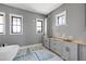 Bathroom features white cabinets, a large tub, and ample natural light from three windows at 6509 Zebulon Rd, Wake Forest, NC 27587