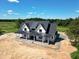 Aerial view of new modern farmhouse with black metal roof and inviting front porch at 6509 Zebulon Rd, Wake Forest, NC 27587