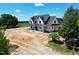 Aerial view of new modern farmhouse with black metal roof and inviting front porch at 6509 Zebulon Rd, Wake Forest, NC 27587