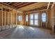 A living room with exposed framing has plenty of light from the windows and a glass door at 6509 Zebulon Rd, Wake Forest, NC 27587