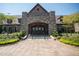 Stone clubhouse entrance with an arched entryway, double doors, and well-maintained landscaping at 7220 Hasentree Way, Wake Forest, NC 27587