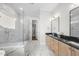 This modern bathroom features a glass shower, marble tiling, and a wooden vanity with a black countertop at 729 Daniel Ridge Rd, Wendell, NC 27591