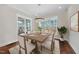 Bright dining room featuring modern lighting, a wooden table set for six, and large windows offering views of the outdoors at 729 Daniel Ridge Rd, Wendell, NC 27591