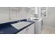 Well-lit laundry room features a white washer and dryer, shelving, and navy countertops with white cabinetry at 729 Daniel Ridge Rd, Wendell, NC 27591