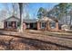 Charming brick home featuring black shutters, a well-manicured front lawn, and a detached garage in a wooded setting at 733 Shadywood Ln, Raleigh, NC 27603