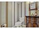 Powder room featuring striped wallpaper and a decorative vanity at 7712 Falcon Rest Cir, Raleigh, NC 27615
