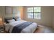 Bright bedroom featuring a large window letting in natural light and a bed with neutral bedding at 7712 Falcon Rest Cir, Raleigh, NC 27615