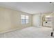 This is a carpeted bedroom with a window and a doorway to an en-suite bathroom at 7712 Falcon Rest Cir, Raleigh, NC 27615