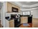 Bright kitchen with wood cabinets, granite counters, and black appliances at 7712 Falcon Rest Cir, Raleigh, NC 27615