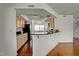 Open kitchen with black countertops, wood cabinets, and hardwood floors at 7712 Falcon Rest Cir, Raleigh, NC 27615