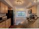 The kitchen features wood cabinets, black appliances, a breakfast nook, and hardwood floors at 7712 Falcon Rest Cir, Raleigh, NC 27615