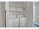 Laundry room area with washer, dryer, shelving, and bench seating at 7712 Falcon Rest Cir, Raleigh, NC 27615