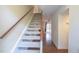 View of carpeted staircase and hallway leading to a living area with hardwood floors and sliding glass door at 7712 Falcon Rest Cir, Raleigh, NC 27615