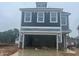 New two-story home with gray siding and a two-car garage with the door open at 79 Willow Cameron Way, Angier, NC 27501