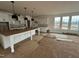 Unfinished kitchen featuring white cabinets, a large island, and natural light from the backyard windows at 79 Willow Cameron Way, Angier, NC 27501