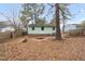 Backyard featuring mature trees, and a glimpse of the home's exterior; inviting outdoor space at 809 S Plum St, Durham, NC 27701