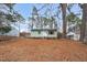 Cozy one-story home with light green siding, windows and mulched landscaping with a tree-covered yard at 809 S Plum St, Durham, NC 27701