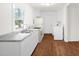 Clean, well-lit kitchen featuring white cabinets, appliances, and sleek hardwood floors at 809 S Plum St, Durham, NC 27701