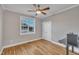 Neutral bedroom with hardwood flooring, ceiling fan, and bright window view at 8116 Hartwood Glen Cir, Willow Springs, NC 27592