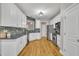 Modern kitchen with stainless appliances, granite countertops, and white cabinets at 8116 Hartwood Glen Cir, Willow Springs, NC 27592