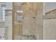 Shower featuring travertine tile, pebble floor and glass doors at 8116 Hartwood Glen Cir, Willow Springs, NC 27592