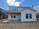 View of the rear of the home with patio, covered area, light siding and dark trim at 89 Willow Cameron Way, Angier, NC 27501