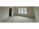 Spacious bedroom in a new home featuring three large windows offering natural light at 89 Willow Cameron Way, Angier, NC 27501