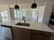 Kitchen island featuring stainless steel dishwasher, plenty of counter space, a large sink, and modern fixtures at 89 Willow Cameron Way, Angier, NC 27501
