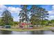 Lakeside park featuring playground, tall pines, green restrooms, red barn, and scenic views at 89 Willow Cameron Way, Angier, NC 27501