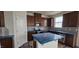 This kitchen features brown cabinetry, stainless steel appliances, and a white central island at 921 Emmer St, Rolesville, NC 27571