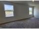 Bedroom features neutral walls, carpet, and two windows that let in natural light at 937 Emmer St, Rolesville, NC 27571