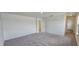 Spacious carpeted bedroom features a light-colored walls, multiple windows, and a door at 937 Emmer St, Rolesville, NC 27571