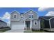 Two-story home with gray siding, a white garage door, and a front porch at 937 Emmer St, Rolesville, NC 27571