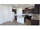 Contemporary kitchen with dark wood cabinets, white island, and stainless steel appliances at 937 Emmer St, Rolesville, NC 27571