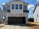 Two-story home under construction with a prominent two-car garage and light blue siding at 98 Willow Cameron Way, Angier, NC 27501
