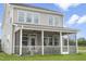 Rear view of a two-story home with a screened porch overlooking a well-manicured lawn at 98 Willow Cameron Way, Angier, NC 27501
