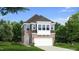 Charming two-story home features a stone and gray exterior, a two-car garage, and manicured landscaping at 98 Willow Cameron Way, Angier, NC 27501