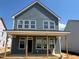 Two-story home with light blue siding with large windows under construction at 98 Willow Cameron Way, Angier, NC 27501