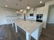 Spacious kitchen with white cabinets, stainless steel appliances and a large center island at 98 Willow Cameron Way, Angier, NC 27501