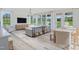 Bright, open-concept living room with modern furniture, light wood floors, and a view of the green outdoors at 98 Willow Cameron Way, Angier, NC 27501