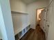 Mudroom with custom white bench seating and storage and door to the half bathroom at 98 Willow Cameron Way, Angier, NC 27501