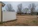 View of the backyard featuring a privacy fence, dormant grass, and a glimpse of a covered car in the distance at 9805 Precious Stone Dr, Wake Forest, NC 27587